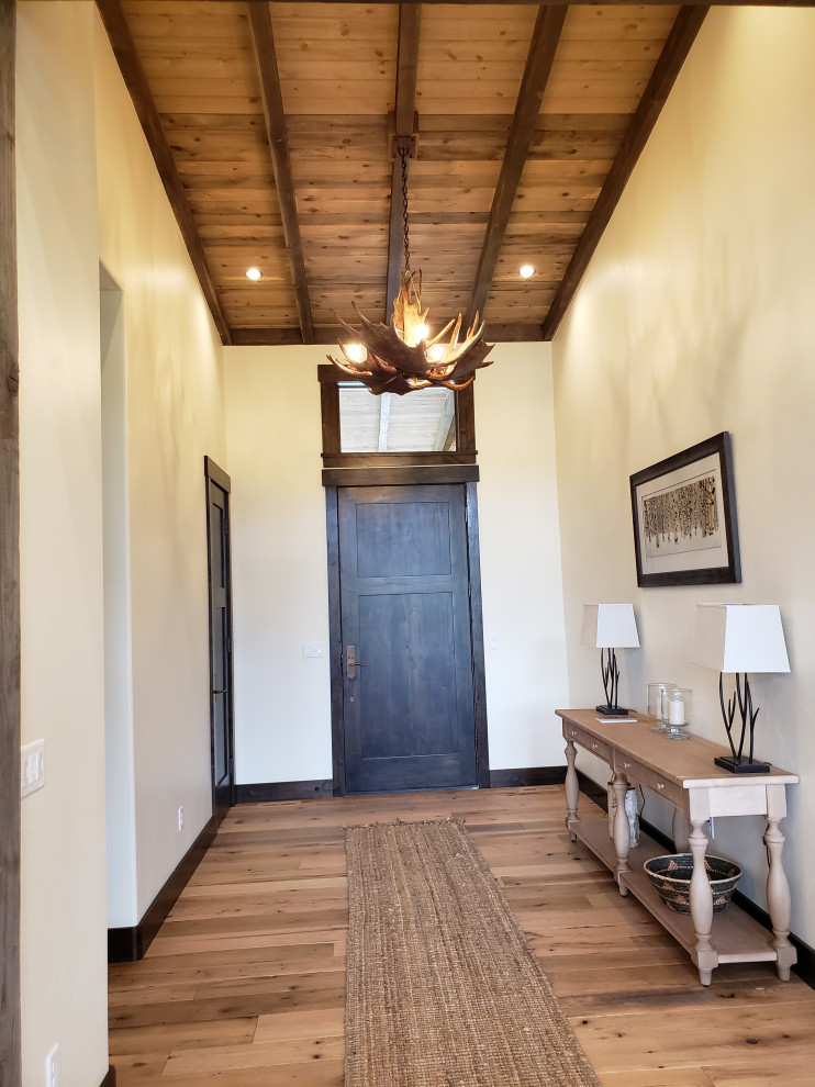Example of a mid-sized mountain style light wood floor and brown floor front door design with a dark wood front door