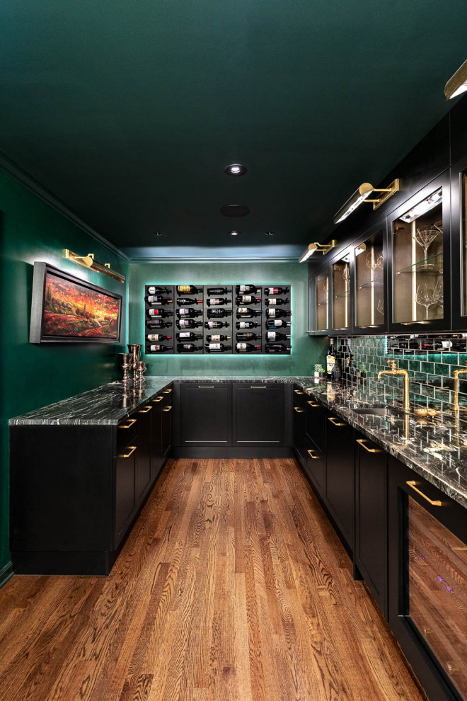 Inspiration for a large eclectic u-shaped wet bar in Detroit with an undermount sink, glass-front cabinets, black cabinets, quartzite benchtops, grey splashback, mirror splashback, medium hardwood floors, brown floor and black benchtop.