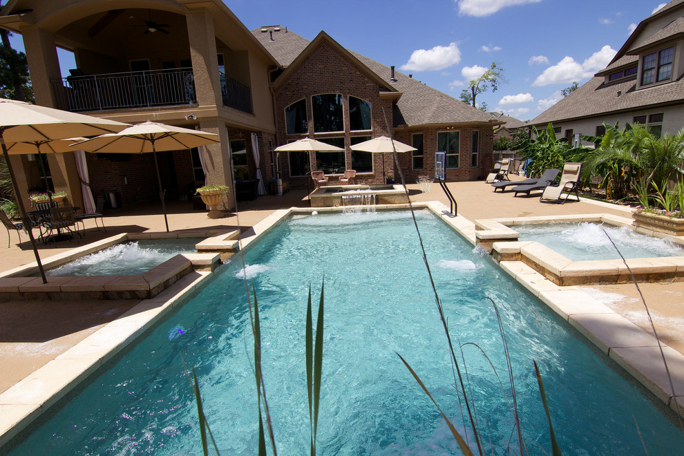 Inspiration for a mid-sized beach style backyard rectangular pool in Houston with a hot tub and stamped concrete.