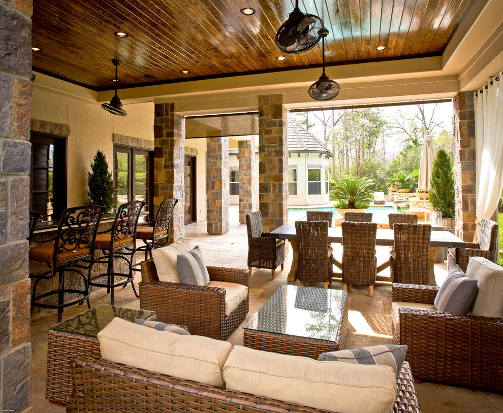 Inspiration for an expansive mediterranean backyard patio in Houston with a fire feature, tile and a roof extension.