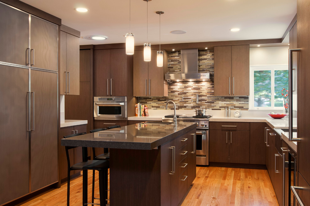 This is an example of a contemporary u-shaped kitchen in San Francisco with a farmhouse sink, flat-panel cabinets, dark wood cabinets, quartz benchtops, brown splashback, matchstick tile splashback and panelled appliances.