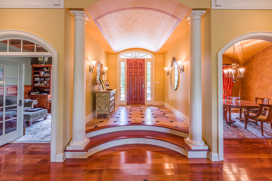 Design ideas for a large traditional foyer in New York with yellow walls, medium hardwood floors, a single front door and a medium wood front door.