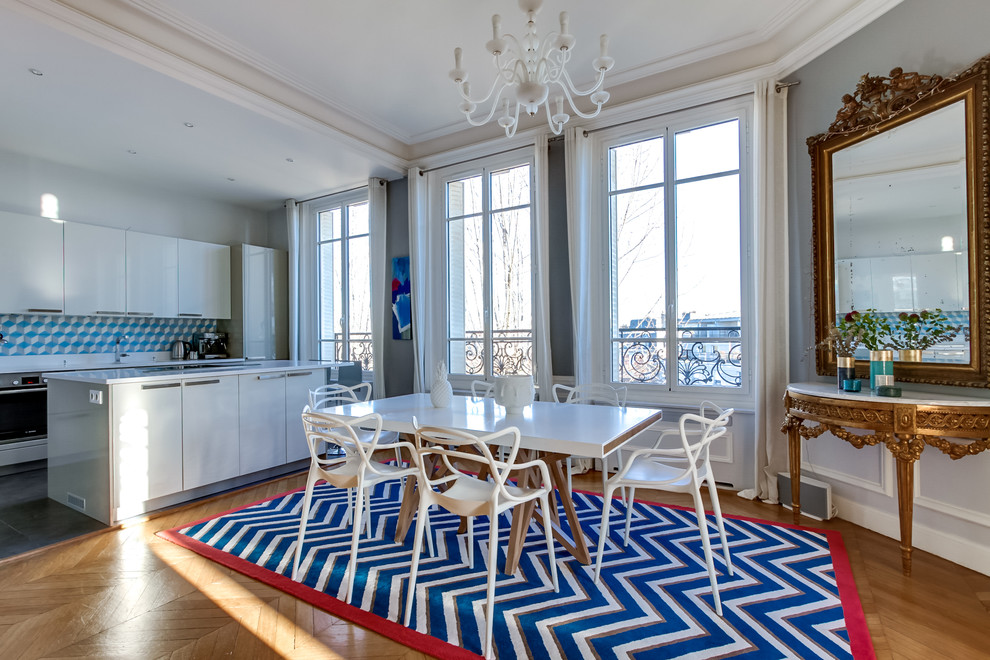 Large transitional kitchen/dining combo in Paris with grey walls and light hardwood floors.