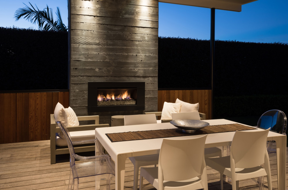 Medium sized contemporary back ground level terrace in Auckland with a fireplace.