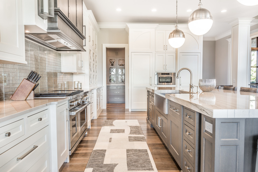 Example of a transitional l-shaped kitchen design with flat-panel cabinets and an island