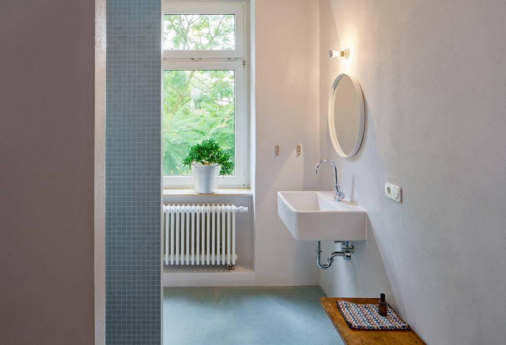 Duschbad With bodengleicher Dusche, Wandtoilette, blauen Fliesen, Mosaikfliesen, weißer Wandfarbe, Mosaik-Bodenfliesen, Wandwaschbecken, blauem Boden, offener Dusche and Einzelwaschbecken in Leipzig