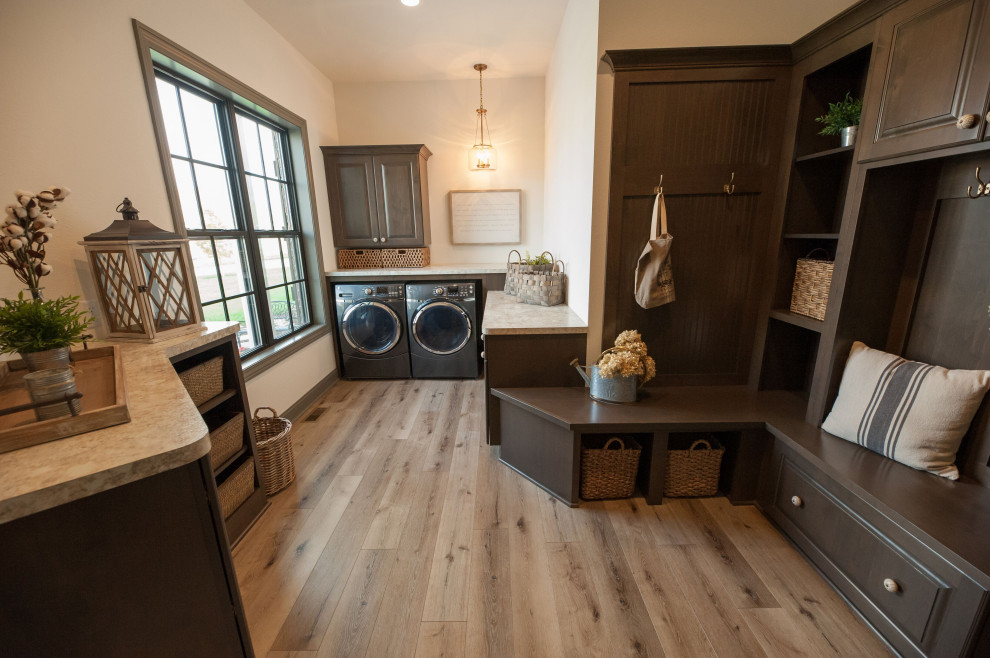 Inspiration for a laundry room in Milwaukee with raised-panel cabinets, brown cabinets, a side-by-side washer and dryer, brown floor and beige benchtop.
