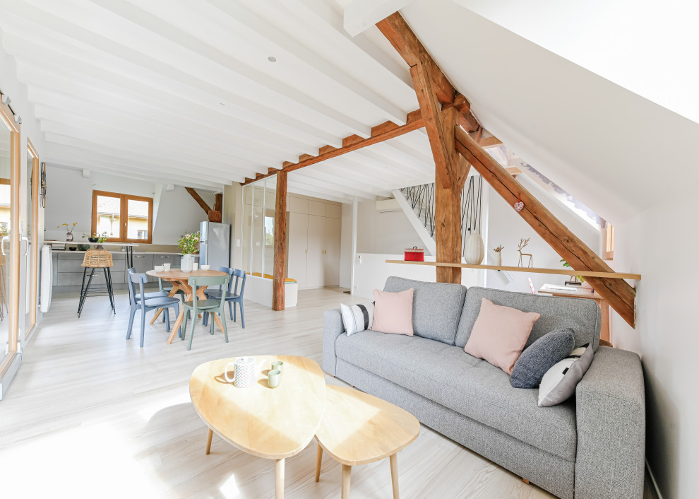 Foto de sala de estar con biblioteca abierta escandinava de tamaño medio con paredes blancas, suelo de madera clara y vigas vistas