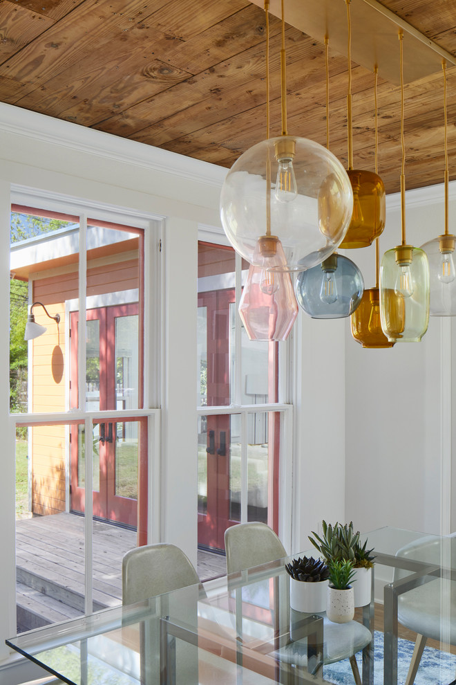 Example of a mid-sized eclectic medium tone wood floor and brown floor enclosed dining room design in Austin with white walls and no fireplace