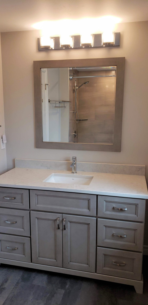 Design ideas for a mid-sized transitional bathroom in Toronto with recessed-panel cabinets, beige cabinets, beige tile, beige walls, vinyl floors, an undermount sink, quartzite benchtops, grey floor, white benchtops, a single vanity and a freestanding vanity.