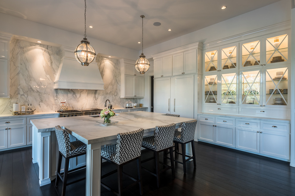 Large transitional galley dark wood floor and white floor eat-in kitchen photo in Houston with a drop-in sink, shaker cabinets, white cabinets, granite countertops, white backsplash, stainless steel appliances and an island
