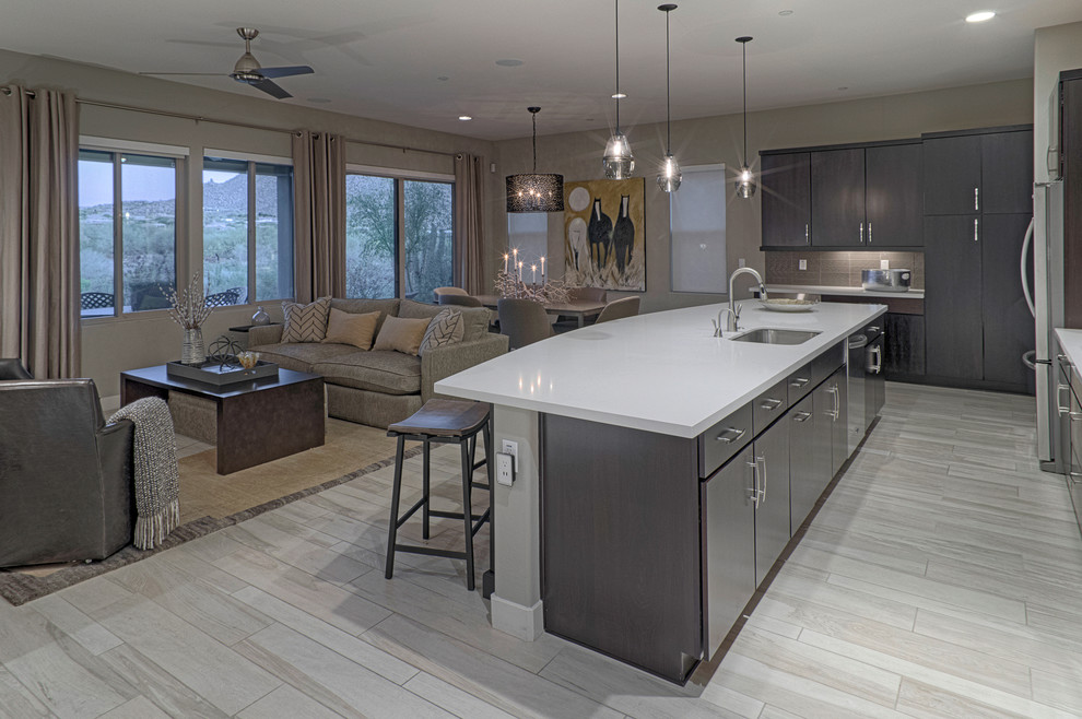 Photo of a large modern l-shaped open plan kitchen in Phoenix with an undermount sink, flat-panel cabinets, dark wood cabinets, quartz benchtops, white splashback, stainless steel appliances, light hardwood floors and with island.