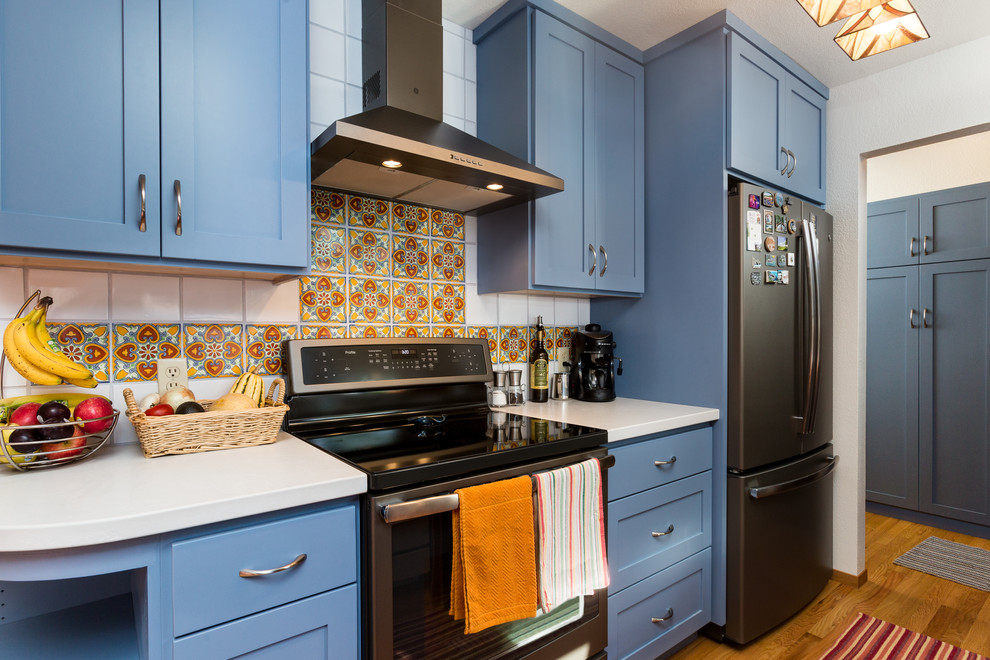 Small galley eat-in kitchen in Other with a farmhouse sink, shaker cabinets, blue cabinets, quartz benchtops, orange splashback, porcelain splashback, stainless steel appliances, dark hardwood floors, no island and white benchtop.