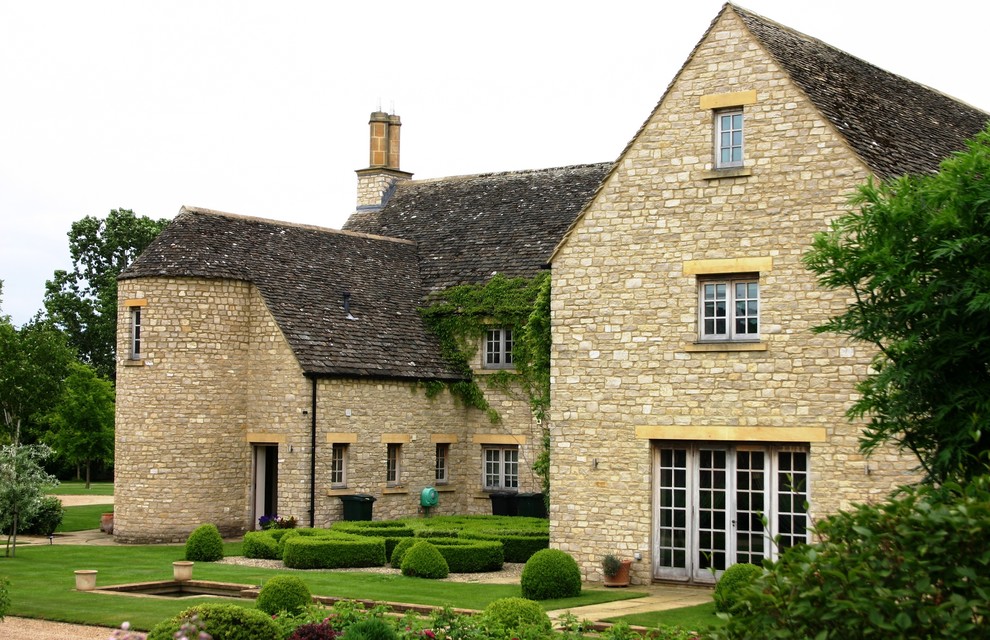 Traditional three-storey beige exterior in Wiltshire with stone veneer and a gable roof.