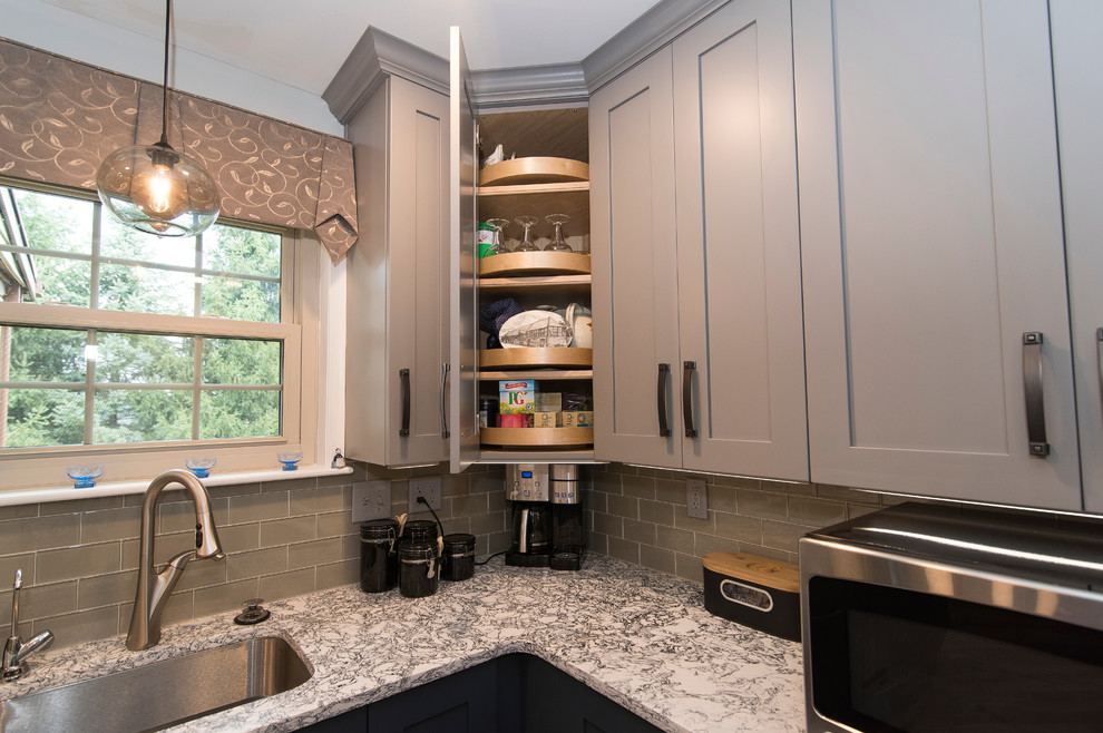 Example of a mid-sized transitional l-shaped brown floor eat-in kitchen design in Baltimore with a single-bowl sink, shaker cabinets, gray cabinets, quartz countertops, gray backsplash, subway tile backsplash, stainless steel appliances, an island and white countertops