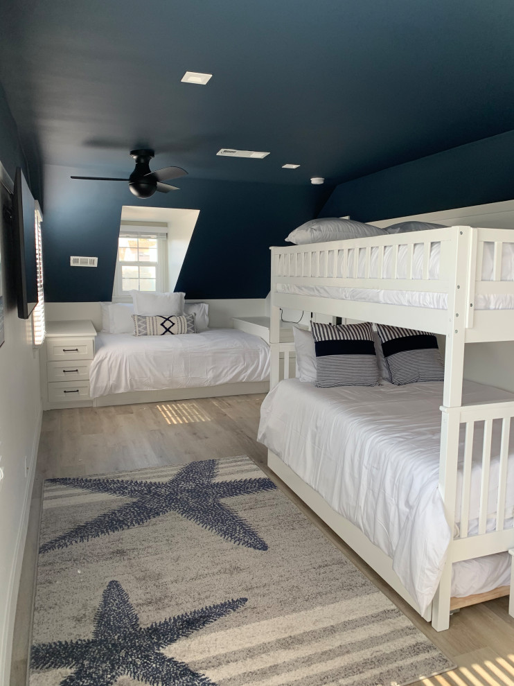 Aménagement d'une petite chambre d'amis bord de mer avec un mur bleu, un sol en vinyl, un sol beige et boiseries.