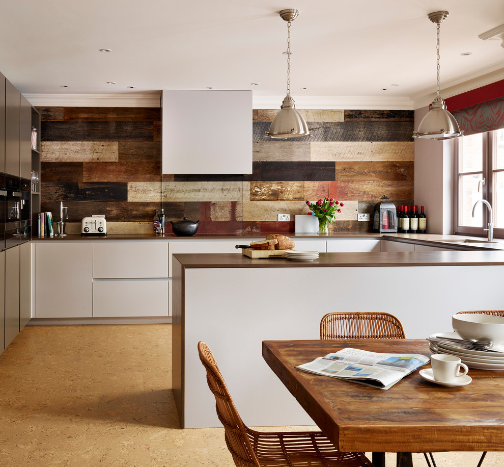 Inspiration for a mid-sized contemporary u-shaped eat-in kitchen in London with grey cabinets, quartzite benchtops, cork floors, with island, an undermount sink, flat-panel cabinets, brown splashback and black appliances.