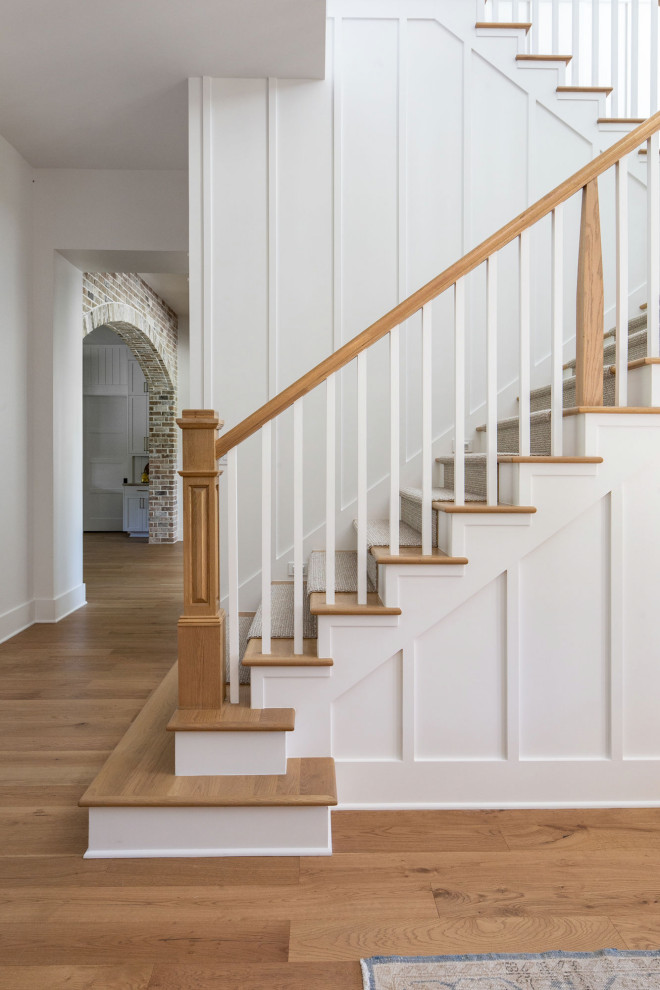 Пример оригинального дизайна: большая п-образная лестница в стиле кантри с деревянными перилами, деревянными стенами, ступенями с ковровым покрытием и ковровыми подступенками
