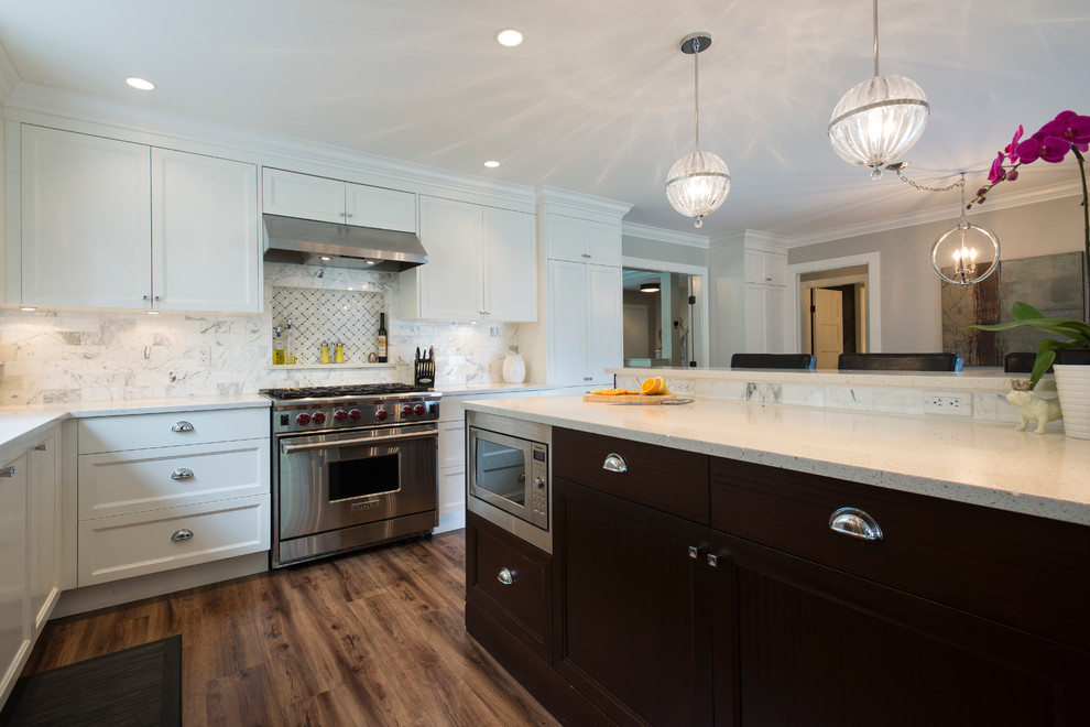 Open concept kitchen - mid-sized transitional l-shaped medium tone wood floor open concept kitchen idea in Vancouver with an undermount sink, shaker cabinets, white cabinets, quartz countertops, white backsplash, stone tile backsplash, stainless steel appliances and an island