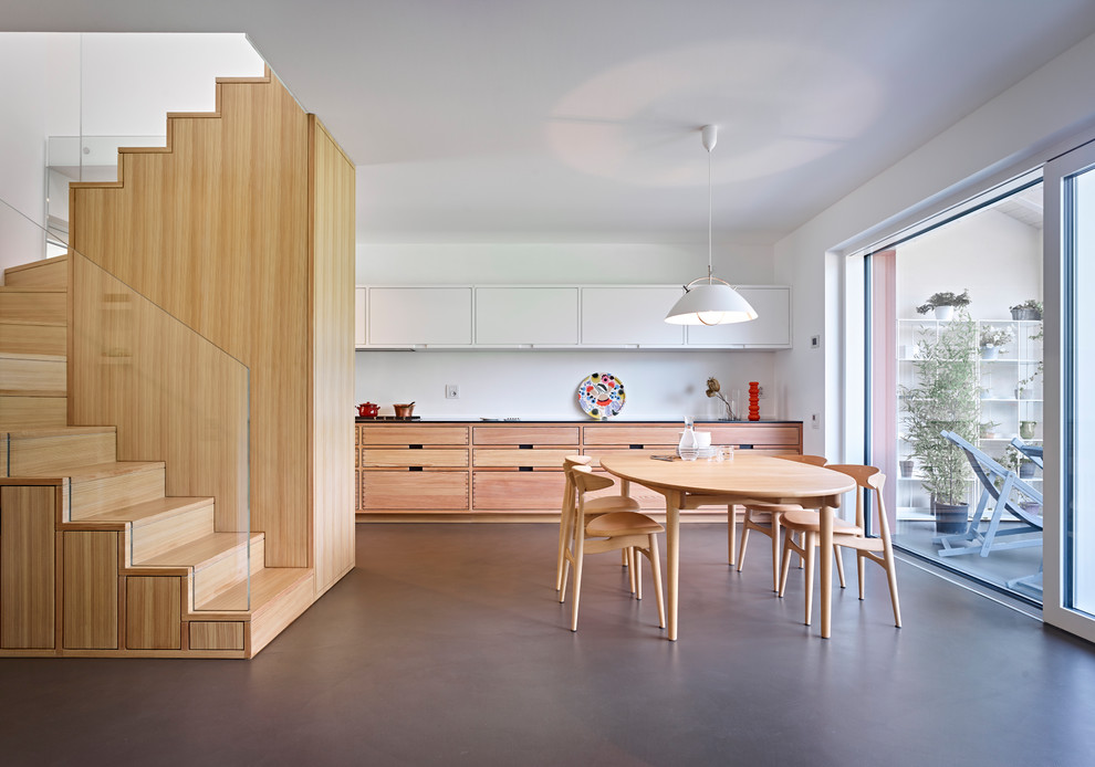 This is an example of a contemporary l-shaped eat-in kitchen in Other with light wood cabinets, wood benchtops, no island and grey floor.