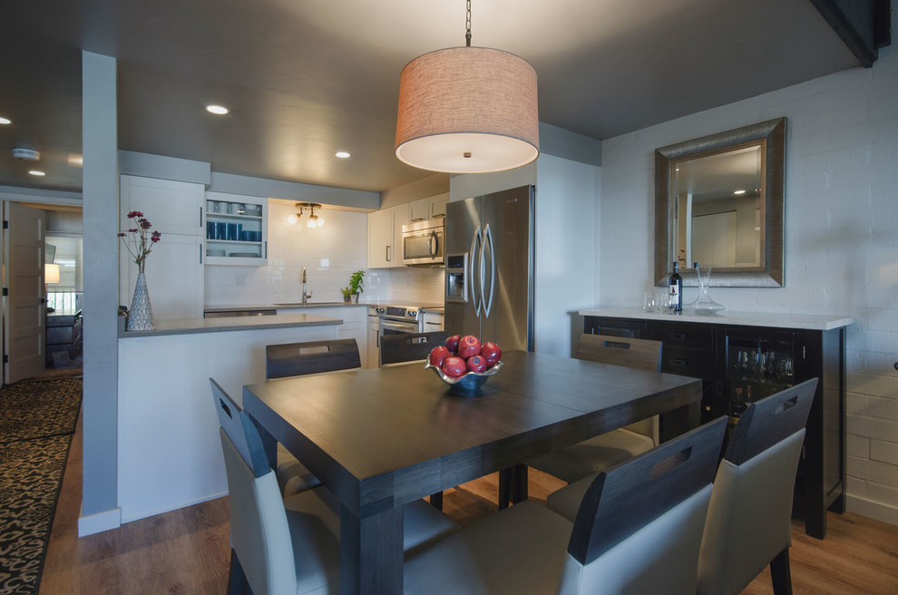 This is an example of a mid-sized contemporary kitchen/dining combo in Denver with white walls and light hardwood floors.