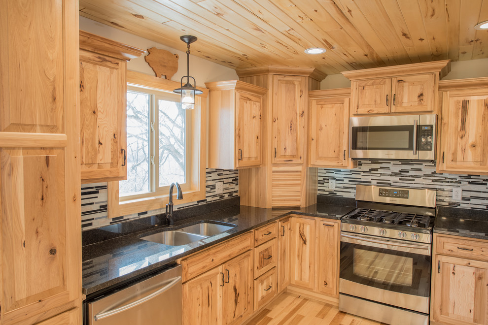 Open concept kitchen - mid-sized rustic l-shaped light wood floor open concept kitchen idea in Minneapolis with a double-bowl sink, raised-panel cabinets, light wood cabinets, granite countertops, multicolored backsplash, matchstick tile backsplash, stainless steel appliances and an island