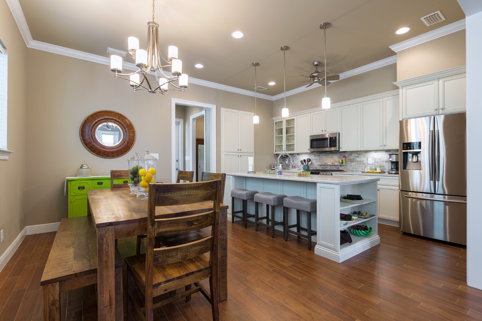Example of a single-wall medium tone wood floor and brown floor eat-in kitchen design with stainless steel appliances, an island and gray backsplash