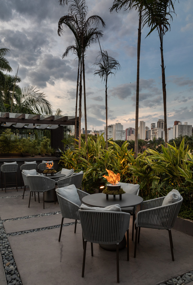 Inspiration for an expansive tropical rooftop and rooftop deck in Miami with with fireplace.