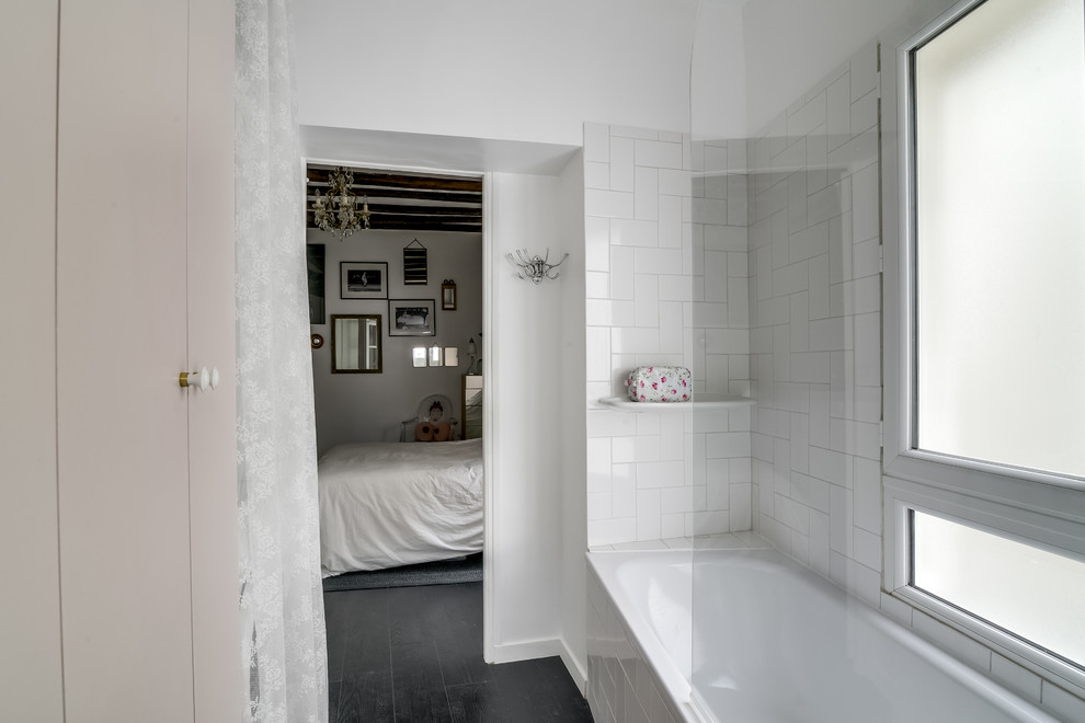 Small traditional master bathroom in Paris with flat-panel cabinets, a drop-in tub, a shower/bathtub combo, white tile, porcelain tile and white walls.