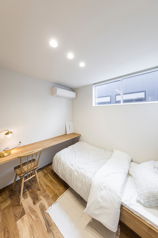 Immagine di una cameretta per bambini da 4 a 10 anni minimalista con pareti bianche, pavimento in legno massello medio, pavimento marrone, soffitto in carta da parati e carta da parati