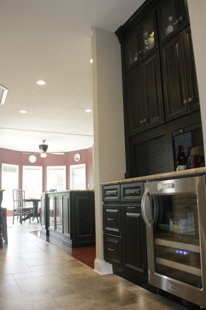 Open concept kitchen - large open concept kitchen idea with an undermount sink, raised-panel cabinets, white cabinets, granite countertops, beige backsplash, stone tile backsplash, stainless steel appliances and an island