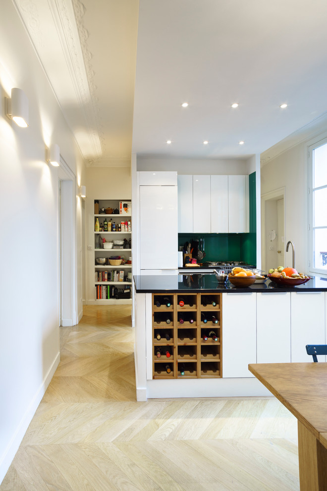 Photo of a large contemporary galley open plan kitchen in Paris with white cabinets and with island.