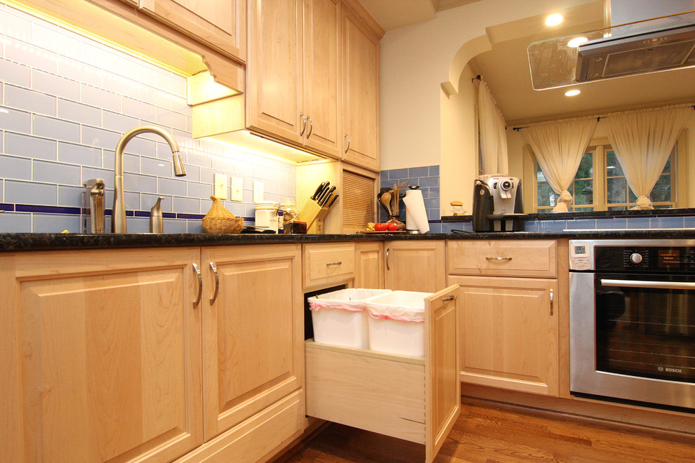 Inspiration for a huge transitional l-shaped medium tone wood floor open concept kitchen remodel with an undermount sink, raised-panel cabinets, light wood cabinets, granite countertops, blue backsplash, glass tile backsplash and stainless steel appliances