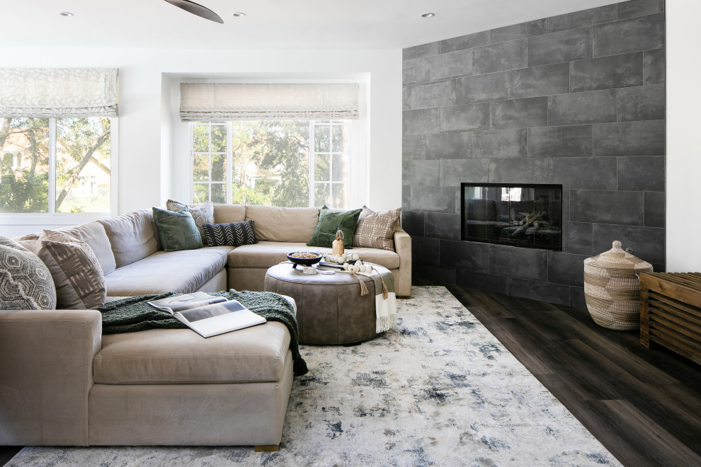Medium sized contemporary open plan living room in Orange County with white walls, vinyl flooring, a corner fireplace, a tiled fireplace surround, a wall mounted tv and brown floors.