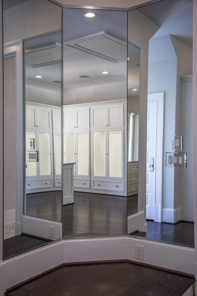 Expansive contemporary gender-neutral dressing room in Atlanta with shaker cabinets, white cabinets and dark hardwood floors.