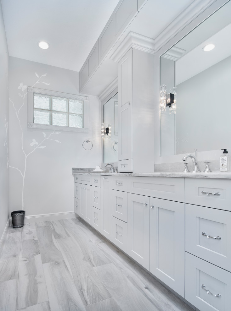 Mid-sized contemporary master bathroom in Miami with recessed-panel cabinets, white cabinets, a curbless shower, a bidet, white tile, marble, white walls, ceramic floors, an undermount sink, engineered quartz benchtops, white floor, a hinged shower door, white benchtops, a double vanity, a built-in vanity and wallpaper.