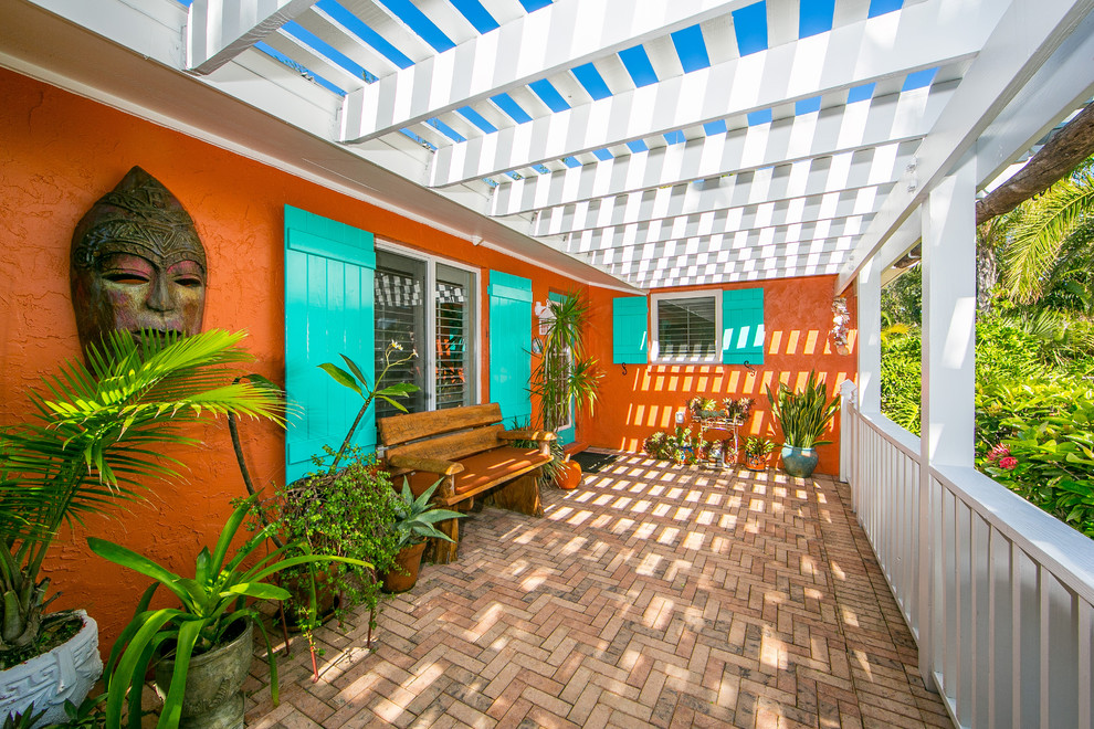 Inspiration for a tropical front door in Tampa with orange walls, a single front door, a blue front door and brown floor.