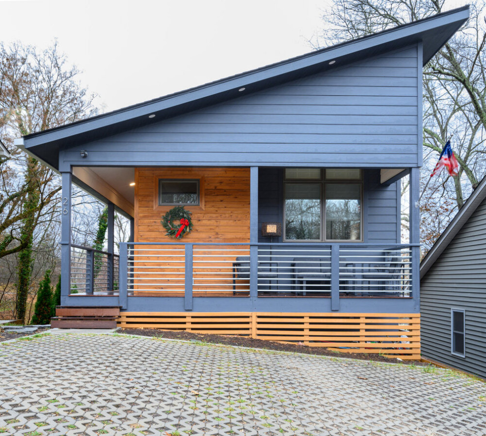 Design ideas for a country two-storey blue house exterior in Other with wood siding, a shed roof and a metal roof.