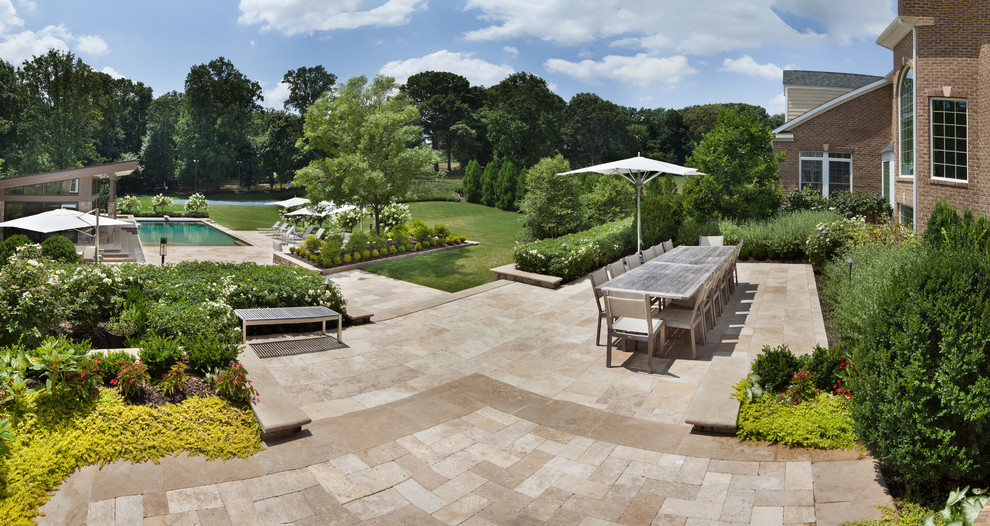 Photo of a large traditional backyard patio in DC Metro with natural stone pavers.