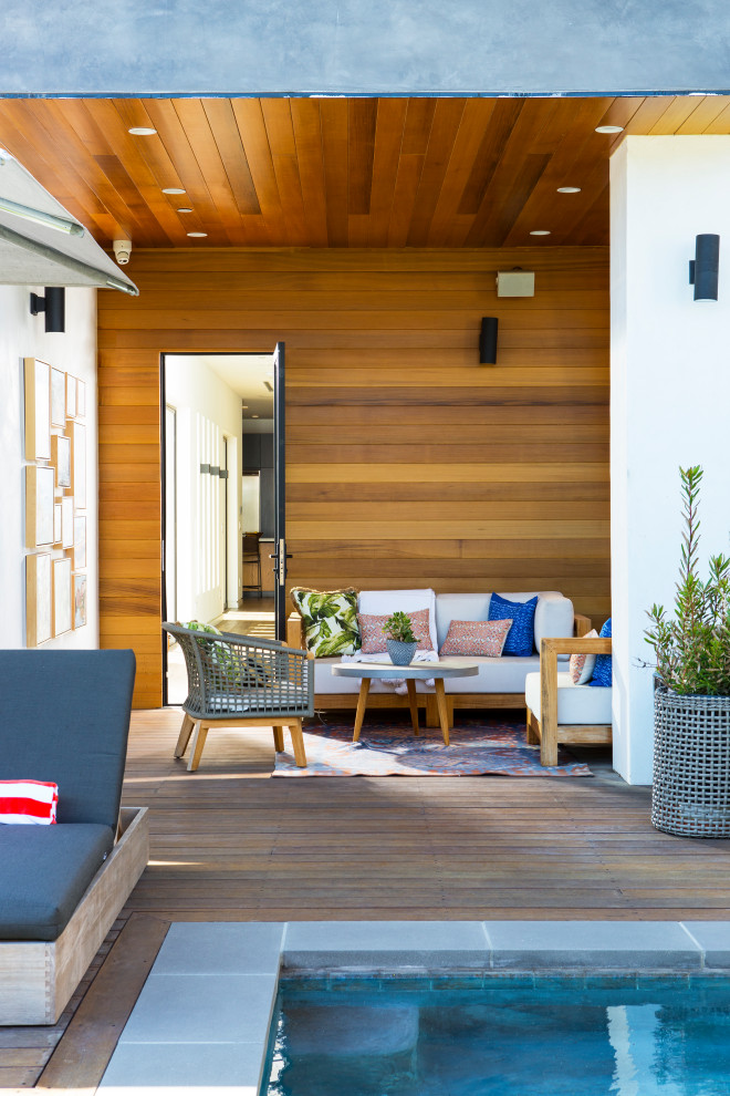 This is an example of a medium sized modern back patio in San Francisco with decking and a roof extension.