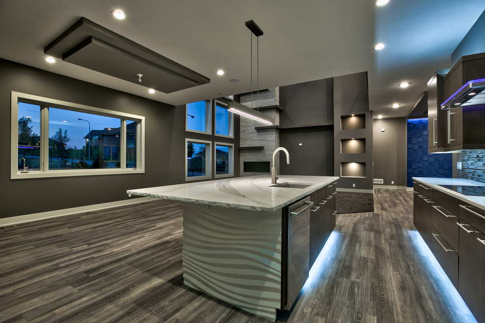 This is an example of a large modern galley eat-in kitchen in Omaha with an undermount sink, flat-panel cabinets, dark wood cabinets, quartzite benchtops, metallic splashback, metal splashback, stainless steel appliances, vinyl floors and with island.
