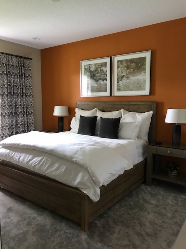 Design ideas for a transitional bedroom in Atlanta with orange walls and beige floor.