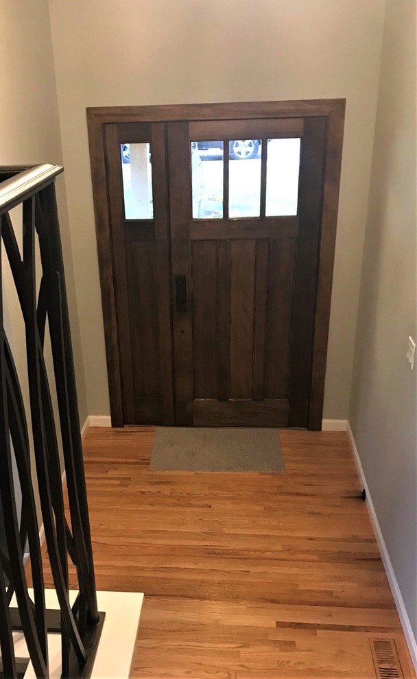 Example of a mid-sized arts and crafts medium tone wood floor and brown floor front door design in Seattle with gray walls and a dark wood front door