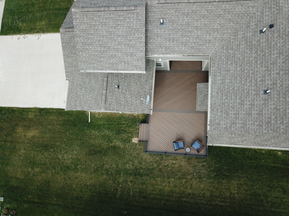 Example of a large courtyard ground level metal railing deck design with no cover