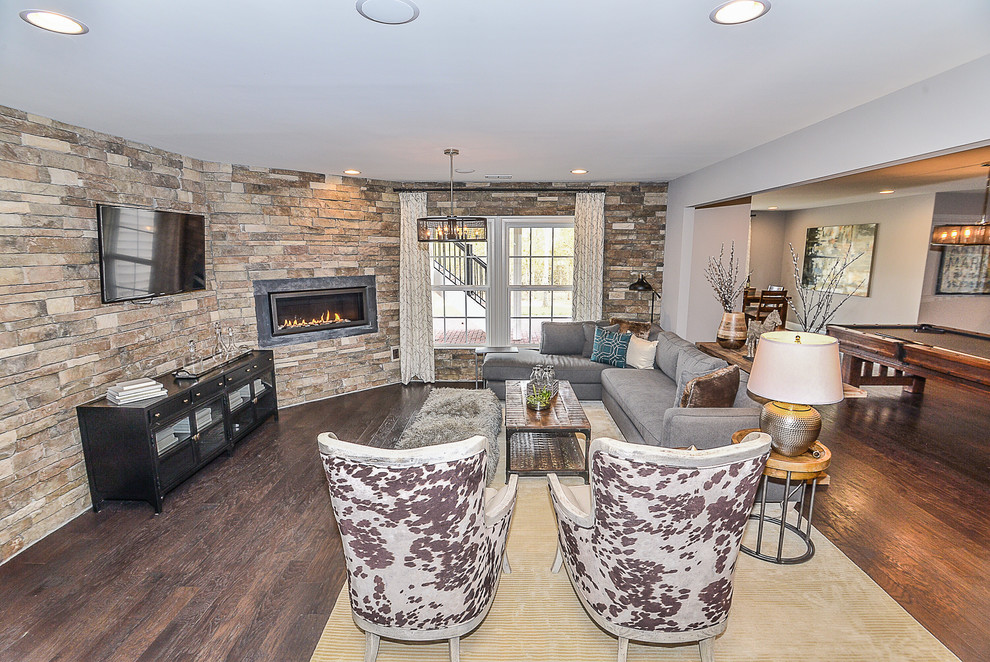 Design ideas for a mid-sized transitional walk-out basement in DC Metro with grey walls, dark hardwood floors, a ribbon fireplace and a tile fireplace surround.