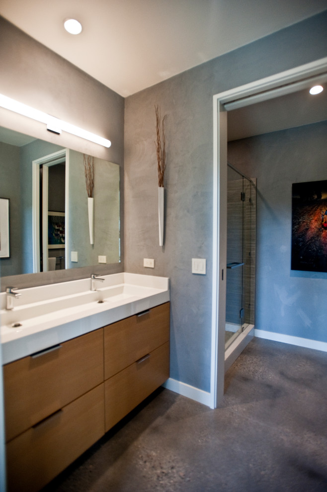 Mid-sized contemporary 3/4 bathroom in Other with flat-panel cabinets, a wall-mount toilet, gray tile, grey walls, concrete floors, an undermount sink, engineered quartz benchtops, grey floor, a hinged shower door, white benchtops, an alcove shower, medium wood cabinets and marble.