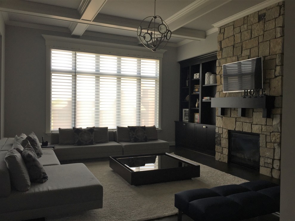 This is an example of a mid-sized contemporary open concept family room in Detroit with grey walls, dark hardwood floors, a standard fireplace, a stone fireplace surround, a wall-mounted tv and brown floor.
