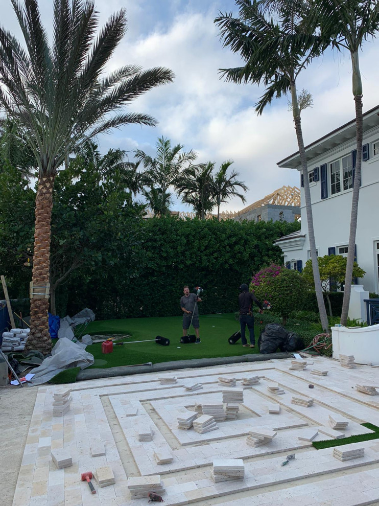 Patio - large contemporary front yard stone patio idea in Miami