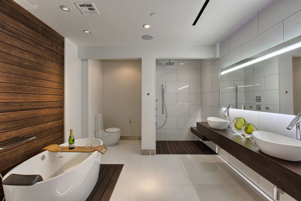 Design ideas for a large contemporary master bathroom in Other with a freestanding tub, an alcove shower, a two-piece toilet, white tile, white walls, a vessel sink, wood benchtops, white floor, an open shower and brown benchtops.