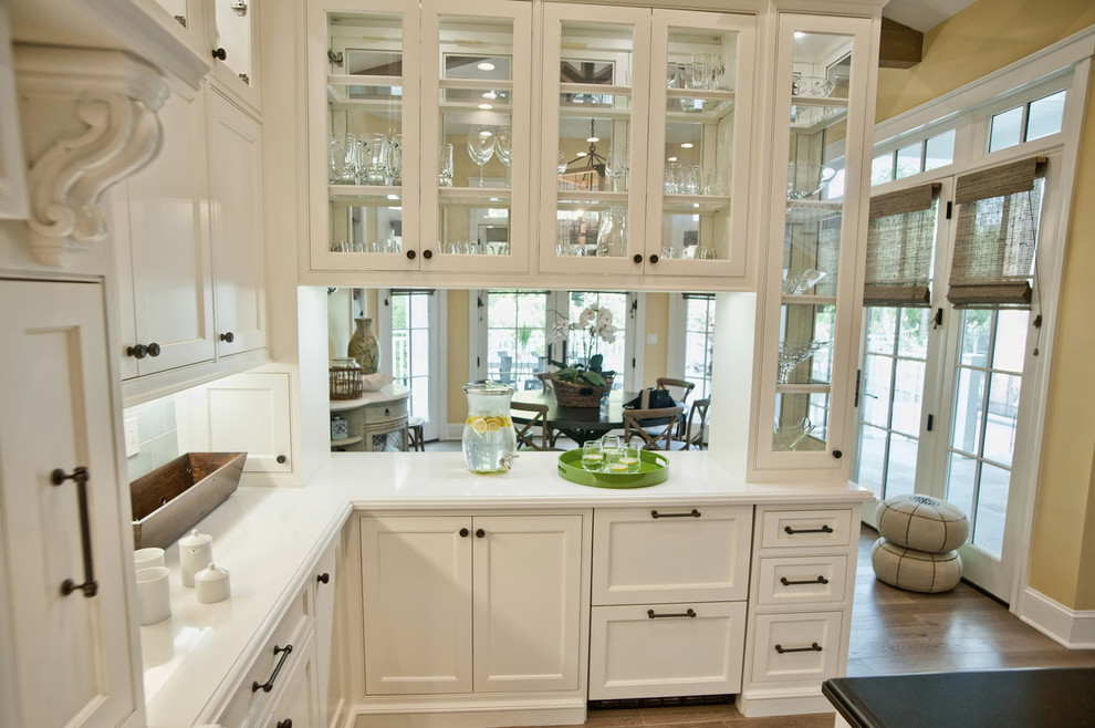 Photo of a traditional kitchen in Los Angeles with glass-front cabinets and white cabinets.